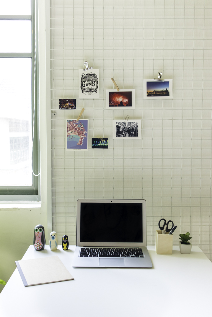 laptop on the table with photos on the wall