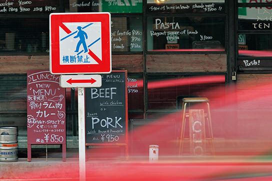 Car with motion blur in front of street sign