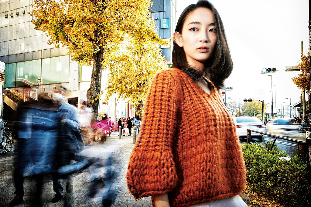 Portrait on busy street with motion blur cars and passers-by