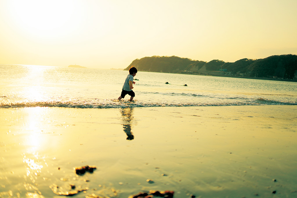 Boy running on seashore during golden hour